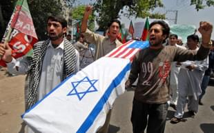 Pakistani Shiite Muslim protesters carry a coffin wrapped in US and Israeli flags during a protest in Peshawar on May 16, 2008 to mark the 60th anniversary of the Jewish state. Al-Qaeda chief Osama bin Laden slammed Western leaders for taking part in Israel’s 60th birthday celebrations and vowed that Muslims would not give up ‘one inch of Palestine,’ in an audio message. AFP PHOTO/Tariq MAHMOOD (Photo credit: TARIQ MAHMOOD/AFP/Getty Images)